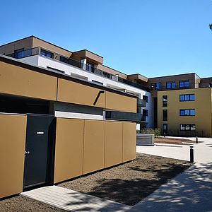 Das Wohnhaus direkt am neu gestalteten Muliarplatz und der Müllraum.