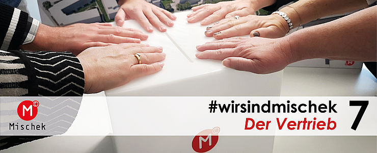 Das Vertriebsteam legt seine Hände geschlossen zusammen.