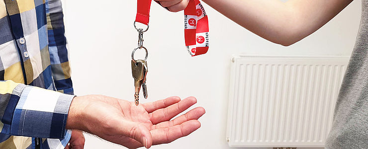 Eine Schlüsselübergabe beim Wohnungskauf.